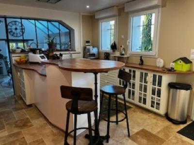 une cuisine avec un bar avec des tabourets et un comptoir dans l'établissement MAISON 24 heures Mans, à Yvré-lʼÉvêque