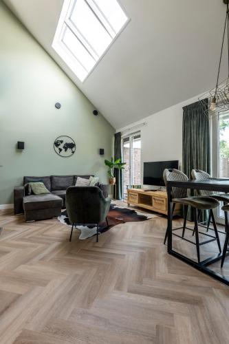 a living room with a couch and a table at Erve Mulder vakantiehuis met eigen jacuzzi en eigen sauna in Weerselo