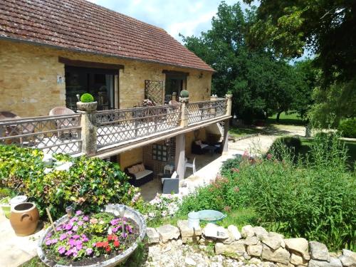 une maison avec balcon et quelques fleurs dans l'établissement Laugerie Basse Gites - Pavot Gite, à Berbiguières