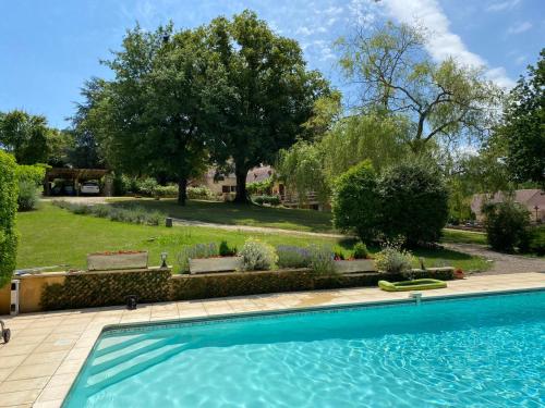 - une grande piscine dans une cour arborée dans l'établissement Laugerie Basse Gites - Pavot Gite, à Berbiguières