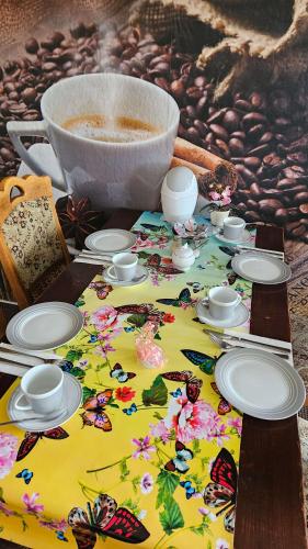 a table with plates and butterflies on it at Pension Garni Zur Schamper Mühle in Gotthun