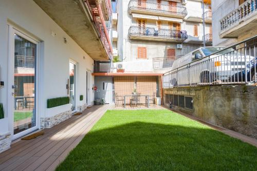 an empty patio with a lawn in the middle of a building at Gatto Matto in Brolo