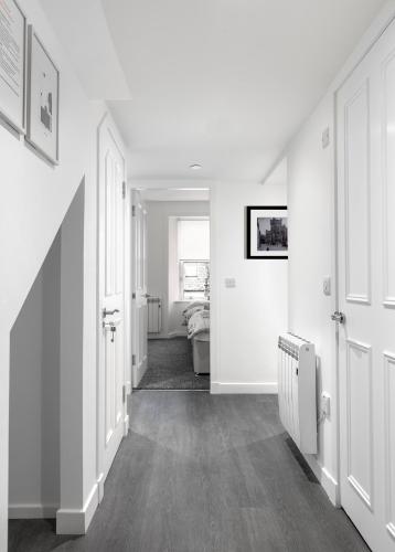 a hallway with white walls and white doors at Castle Street Apartments - Luxury Kilchattan Apartment in Rothesay