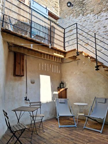 a patio with chairs and tables and a staircase at La Petite Romance - Gîte 3 étoiles in Siran