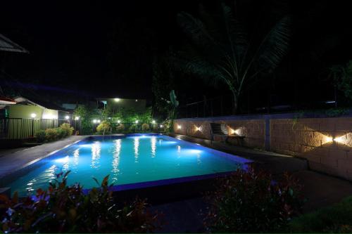 a swimming pool at night with lights on it at sky blue villa in Vythiri