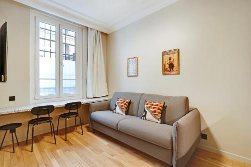 un salon avec un canapé et deux chaises dans l'établissement 4-star apartment just 12 mn from Sacré-Cœur, à Paris