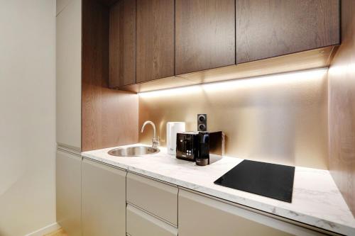 - une cuisine avec un évier et une cafetière sur un comptoir dans l'établissement 4-star apartment just 12 mn from Sacré-Cœur, à Paris