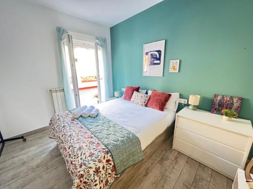 a bedroom with a bed and a blue wall at Las Terrazas de Manzanera con zona exterior by apartamentos Logrono in Logroño