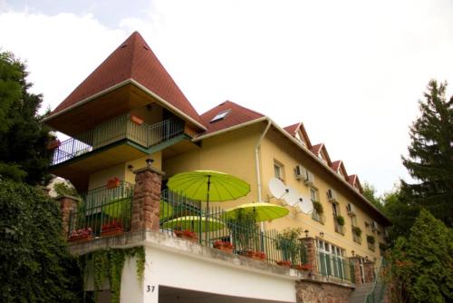 a building with two green umbrellas on a balcony at Gutenberg Villa in Balatonalmádi