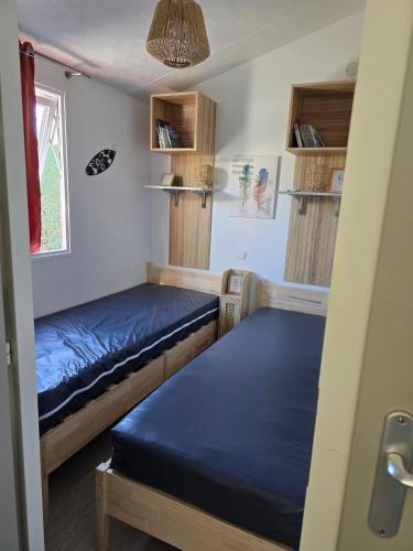 une petite chambre avec deux lits et une fenêtre dans l'établissement family's dream p16 la Marina de canet, à Canet