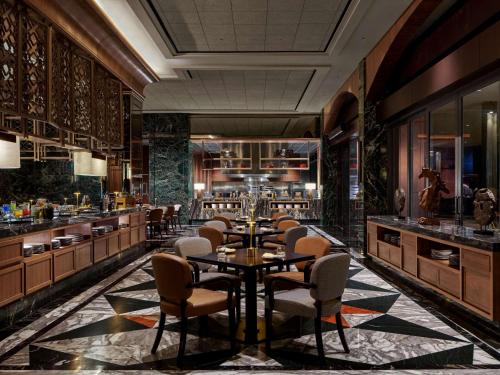 PenajamにあるSwissôtel Nusantaraのテーブルと椅子のあるレストラン、バー