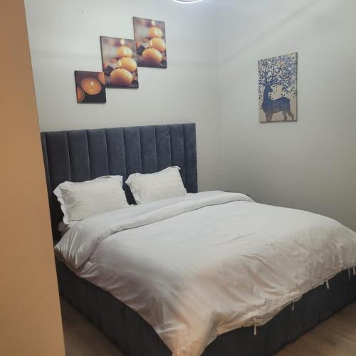 a bed in a bedroom with three pictures on the wall at downtown star in King Abdullah Economic City