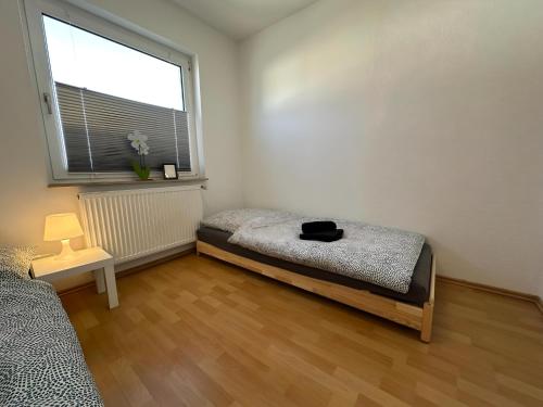 a bedroom with a bed and a large window at FeWo Lindenallee III Modernes Apartment in Nordhorn