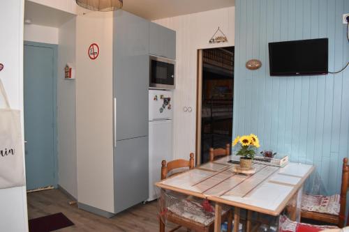 una cucina con tavolo e frigorifero di Appartement hyper centre ville,5pers 'le maloudgja' vue sur le sancy a Le Mont-Dore