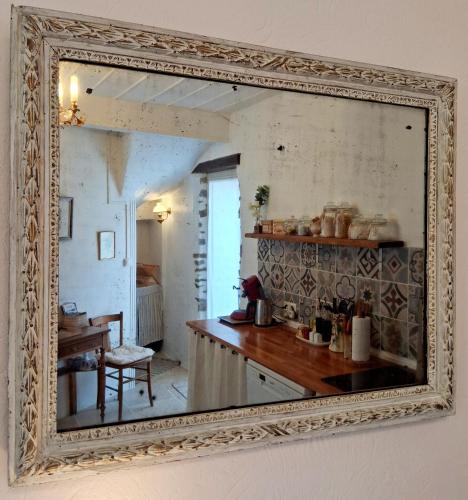 a mirror hanging on a wall in a kitchen at La Petite Romance - Gîte 3 étoiles in Siran
