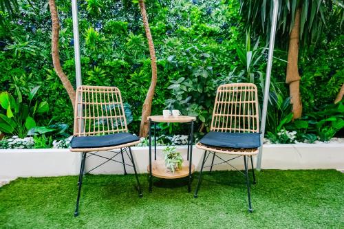 two chairs and a table in front of a garden at Sunset luxury studio by the sea in Athens