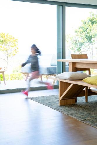 a woman walking in a room with a table and benches at Lefkon Villa with pool by the Sea - NPeloponnese in Kato Rodini