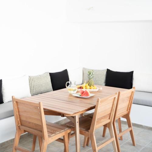 a wooden table with two chairs and a bowl of fruit at Lefkon Villa with pool by the Sea - NPeloponnese in Kato Rodini