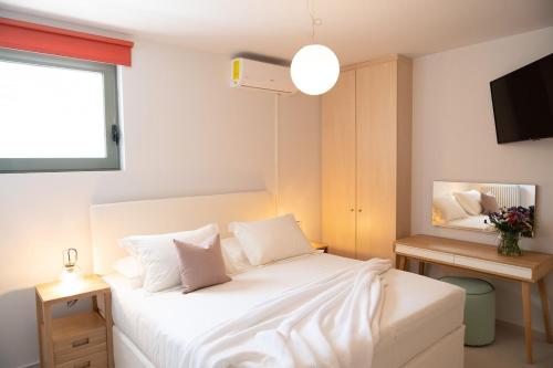 a bedroom with a bed with white sheets and a window at Lefkon Villa with pool by the Sea - NPeloponnese in Kato Rodini