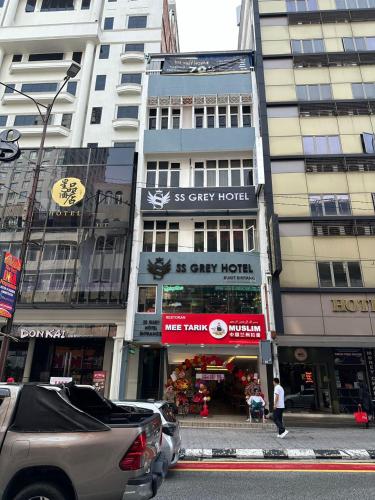 a city street with tall buildings and a car parked in front at SS Grey Hotel Bukit Bintang in Kuala Lumpur