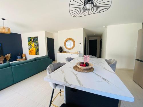 un salon avec une table avec un bol de fruits dessus dans l'établissement La Villa Bohème, à Narbonne