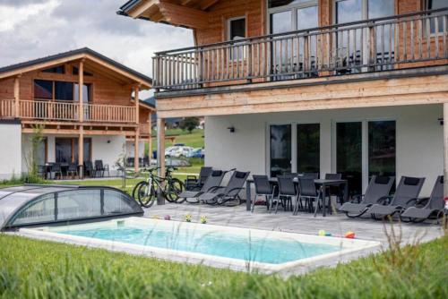 a house with a pool and chairs and a table at Luxalps- Chalets Inzell- Sauna- Skifahren- Wandern- Natur- Chiemgau Card in Inzell