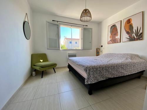 - une chambre avec un lit et une chaise verte dans l'établissement La Villa Bohème, à Narbonne