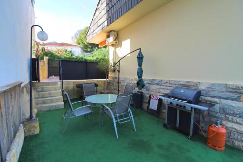 a patio with a table and chairs and a grill at Chalet con piscina y barbacoa in Polop