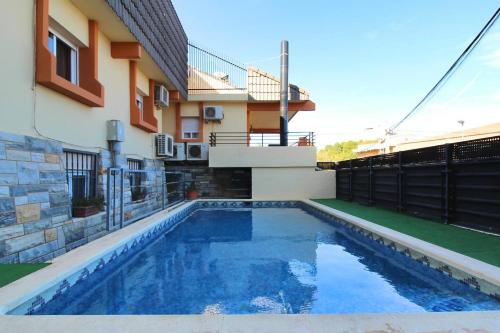 a swimming pool in front of a house at Chalet con piscina y barbacoa in Polop
