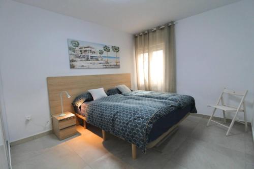 a bedroom with a bed and a lamp and a window at Apartamento Avenida Altea 19 in Altea