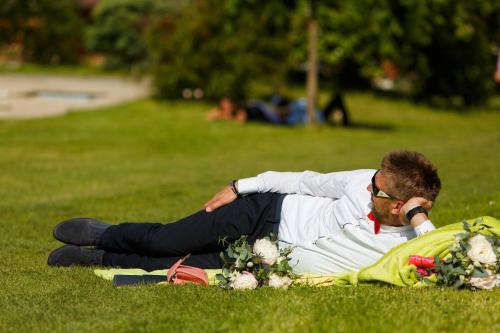 a man laying on the grass in a park at Pension Tereza & Šumavské Roubenky in Sušice