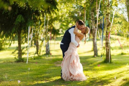a bride and groom kissing in a park at Pension Tereza & Šumavské Roubenky in Sušice
