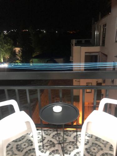 two chairs and a table on a balcony at night at the best apartment in Kutaisi