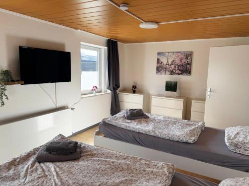 a room with two beds and a flat screen tv at Wohnen auf Zeit in Hückeswagen -Neu- in Hückeswagen