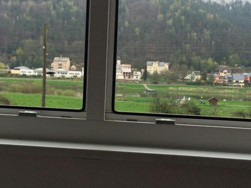 a window with a view of a green field at Pension Hönel-Hof Bad Schandau in Bad Schandau