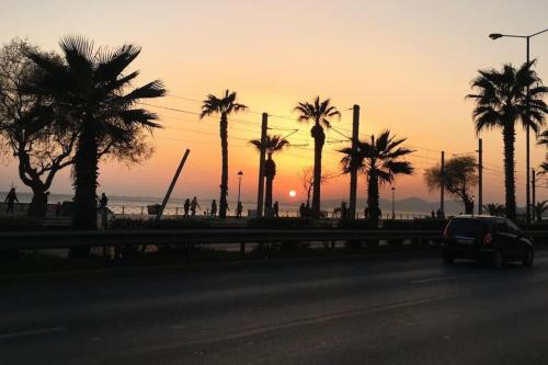 a car driving down a road with palm trees at Sunset luxury studio by the sea in Athens
