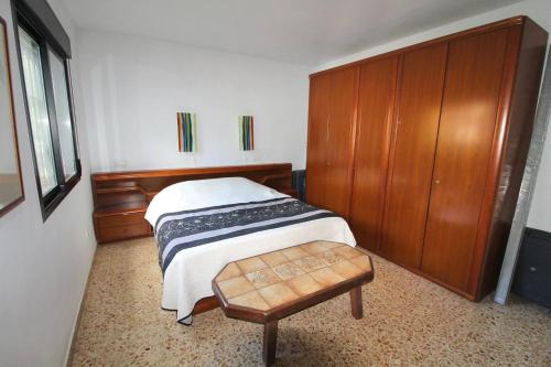 a bedroom with a bed and a wooden cabinet at Chalet a 500m del mar in Altea