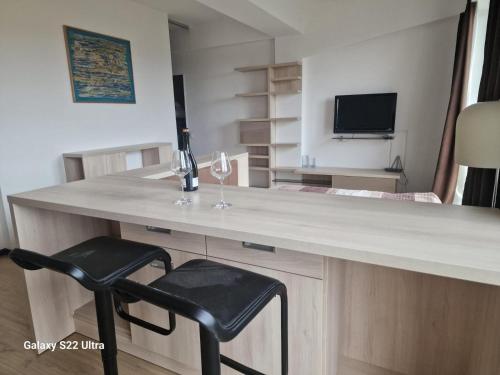a desk with a bottle of wine and a chair at Skyline Chic Apartment 43 in Chişinău