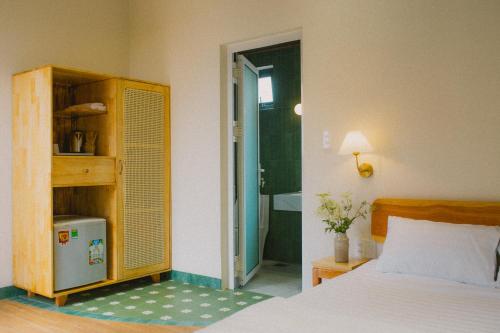 a bedroom with a bed and a closet and a bathroom at Gỗ Bungalow & Homestay in Hoat