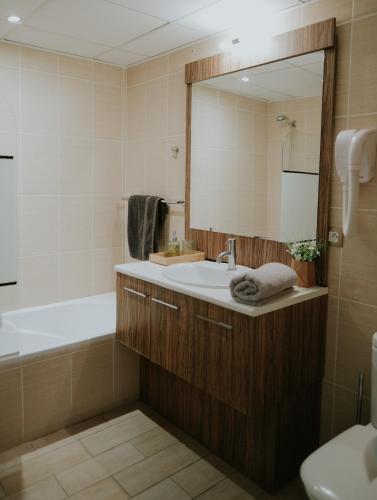 une salle de bain avec un lavabo, une baignoire et un miroir dans l'établissement Appartement 3 pièces Climatisé dans une Résidence avec Piscine, à Callian