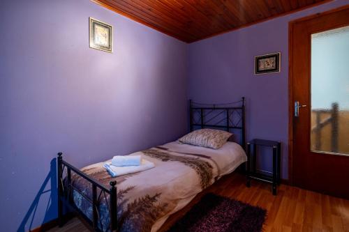 - une chambre avec un lit dans un mur violet dans l'établissement On The Rocks - Alpes Mancelles, à Sillé-le-Guillaume