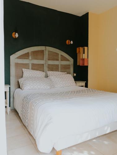 - une chambre avec un grand lit blanc et un mur noir dans l'établissement Appartement 3 pièces Climatisé dans une Résidence avec Piscine, à Callian