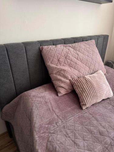a bed with a purple comforter and two pillows at Borovets Gardens MVS Apart D42 in Borovets