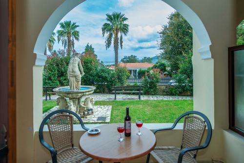 a patio with a table and chairs and a fountain at Fiona Apartments Roda Corfu in Roda