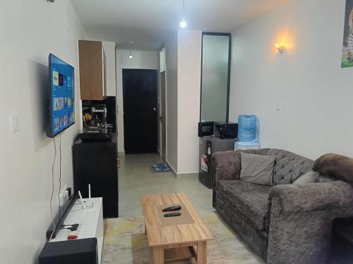 una sala de estar con un sofá y una mesa en Legatus Cozy Studios 1, en Nairobi