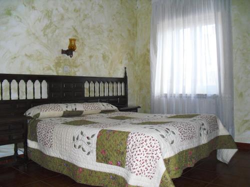 a bedroom with a bed and a window at Hostal Bellas in Ávila