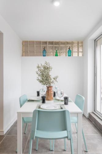 une table à manger avec des chaises bleues et une table blanche dans l'établissement Appart 2 ch - Proche des plages et des Calanques, à Marseille