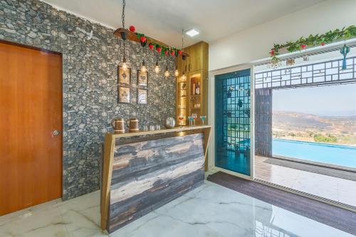 a living room with a large window and a door at CosmicStays Sundown House - Pool Villa near Pawna in Kolvan
