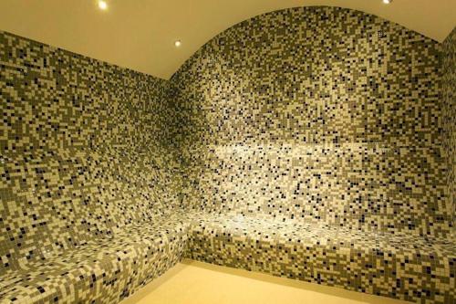 a bathroom with a wall covered in mosaic tiles at CTS Elysium Residence Taksim in Istanbul