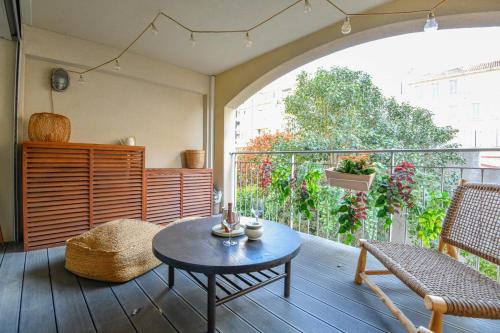 une pièce avec une table et des chaises sur un balcon dans l'établissement Le Mages - Appart 2 ch avec terrasse et parking, à Marseille